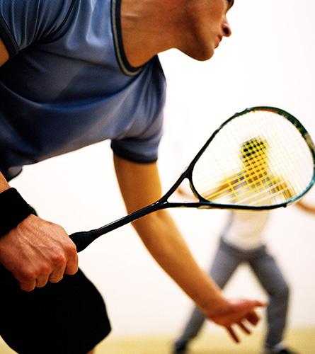 Les hommes jouent au squash. Ce sport est connu pour provoquer des maux de dos